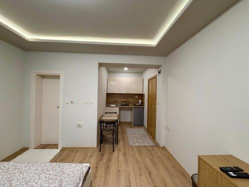 an empty room with a table and a kitchen at Boutique Rooms Desi 1 in Pleven