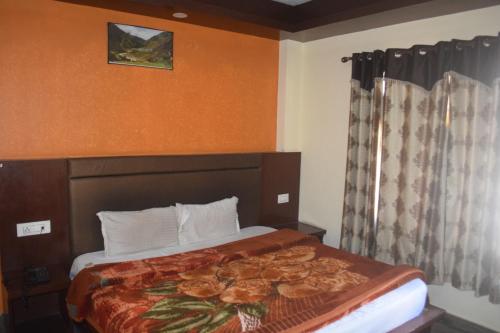 a hotel room with a bed in a room at Hotel Tridev Manali in Manāli