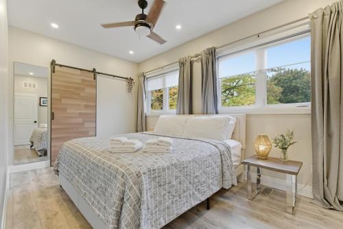 a bedroom with a bed and a window at Redwood Suite - NOTL Prime Location GETAWAY in Niagara-on-the-Lake