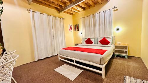 a bedroom with a large bed with red pillows at Piti khangpa in Kaza