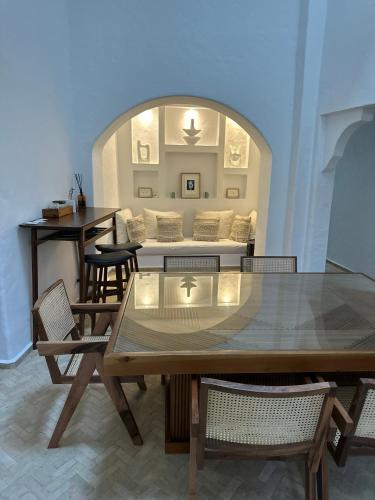 a living room with a table and a couch at Riad Olivia in Asilah