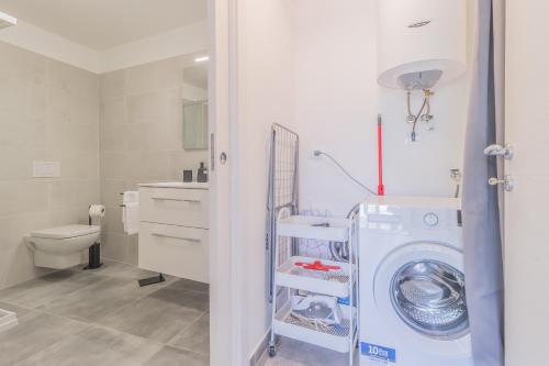 a bathroom with a washing machine and a toilet at La Casetta di Lillie in Lierna