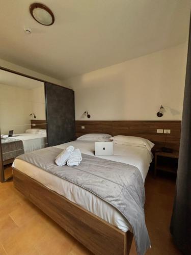 a bedroom with a bed with a laptop on it at Hotel Brixellum in Brescello