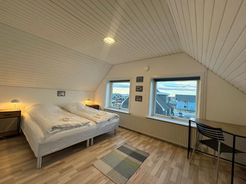 a bedroom with a bed and a large window at Uka Guesthouse Downtown in Nuuk