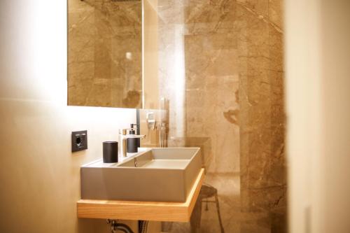 a bathroom with a white sink and a shower at La Casa di Hera in Crotone