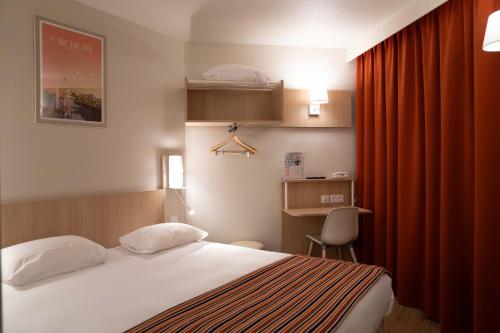 a bedroom with a bed and a red curtain at Hotel Espace Cite in Carcassonne