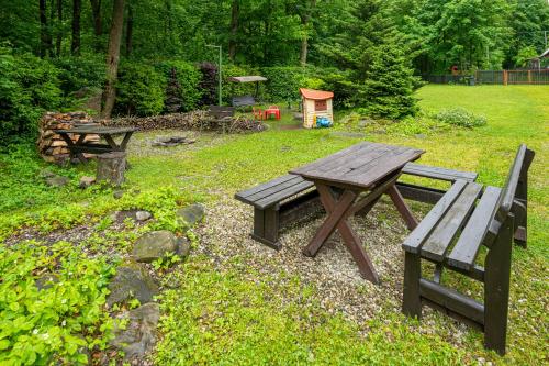 a picnic table and a bench in a yard at Sruby Peřeje in Ostravice