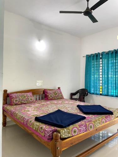 a bed in a room with a ceiling fan at Mango tree room stay in Gokarna