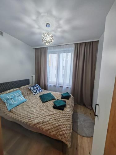 a bedroom with a bed with blue pillows on it at Apartament WLK HOUSE in Gdynia
