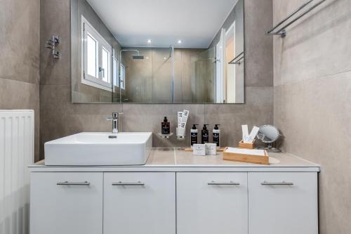a bathroom with a white sink and a mirror at Magdalena Home Corfu in Corfu