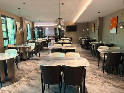 un ristorante con tavoli e sedie in una stanza di Hotel EDEN a Kinshasa