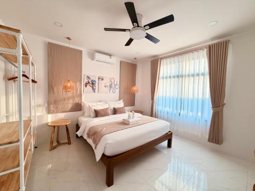 a bedroom with a bed and a ceiling fan at Labelle villa koh phangan in Ko Phangan