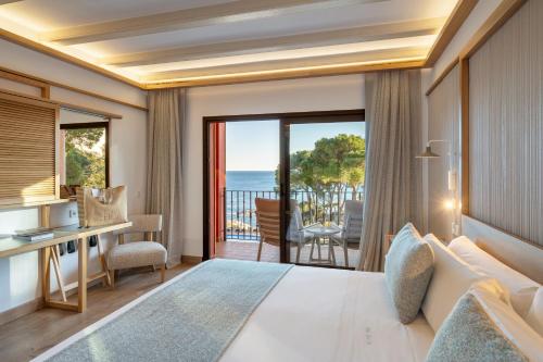a bedroom with a bed and a view of the ocean at Hotel Cala del Pi - Adults Only in Platja d'Aro
