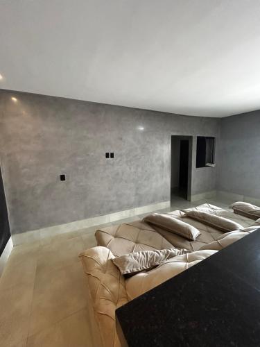 a living room with a long couch in a room at Sobrado Oliveira in Goiânia