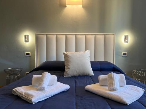 a bedroom with two towels on a blue bed at "La Sala di Dante" Wi-Fi, Smart Tv, AC, Bagno Privato in Pistoia