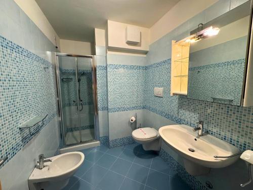 a bathroom with two sinks and a shower and a toilet at Appartamenti La Croma in Grado