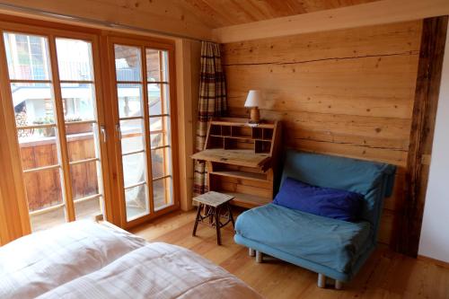 a bedroom with a bed and a chair and a desk at Comfortable quiet apartement with great view in Diemtigen