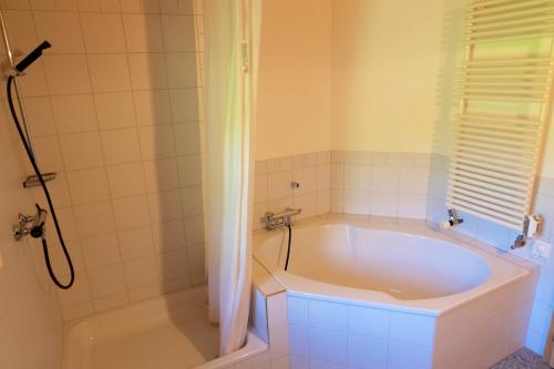 a bathroom with a large tub and a shower at Comfortable quiet apartement with great view in Diemtigen