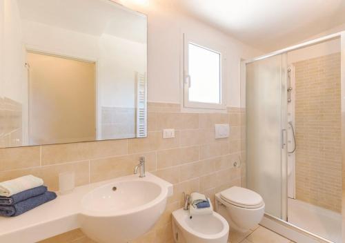 a bathroom with a sink and a toilet and a mirror at Villa Cambretta con giardino, posto auto e a due passi dal mare in Giannella