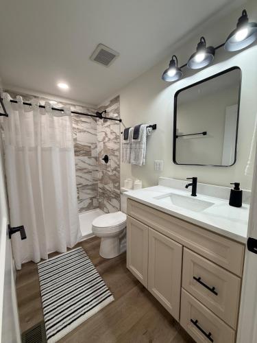 a bathroom with a sink and a toilet and a mirror at Sandstone Lodge in Stanton