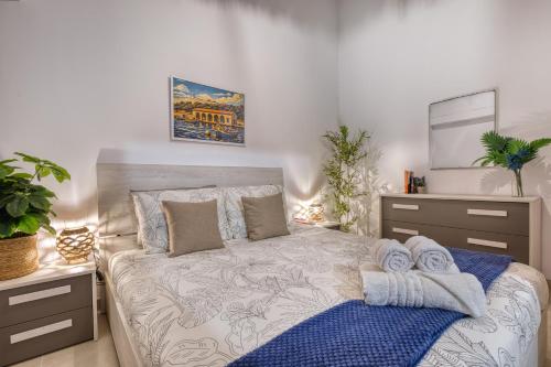 a bedroom with a bed with towels on it at Valletta Marina View - Seafront Apartment in Tal-Pietà
