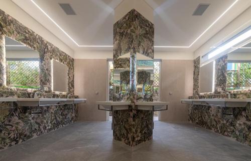 a bathroom with three sinks and mirrors on the wall at Delle Rose Camping & Glamping Village in Isolabona