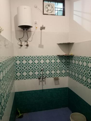 a bathroom with green and white tile on the wall at Krishna Hotel & Restaurant in Devaprayāg