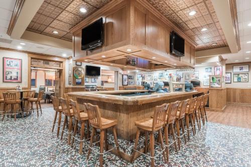 a large kitchen with a large bar with chairs at Ramada by Wyndham State College Hotel & Conference Center in State College