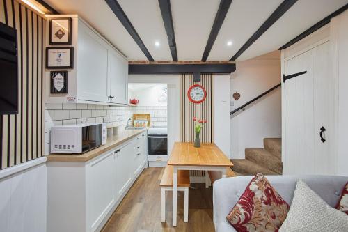 a kitchen and living room with a couch and a table at Host & Stay - Thimble Cottage in Whitby