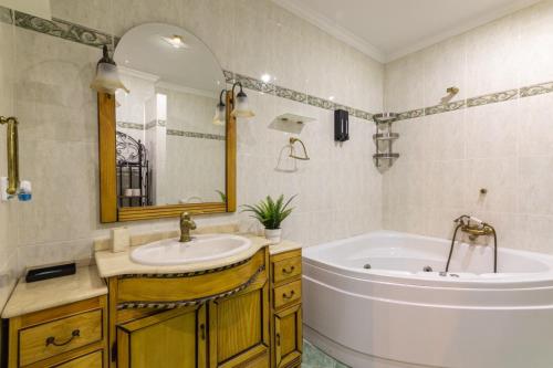 a bathroom with a tub and a sink and a tub and a mirror at La casona de la alberca in La Alberca