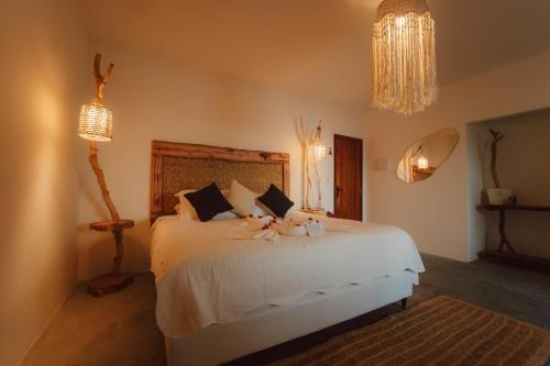 a bedroom with a bed with two stuffed animals on it at Ankura Preá Spa & Boutique Hotel in Cruz