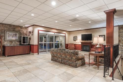 a living room with a couch and a television at Ramada by Wyndham State College Hotel & Conference Center in State College