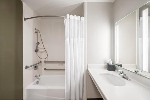 a bathroom with a tub and a sink and a shower at Garner Hotel Idaho Falls Southwest by IHG in Idaho Falls