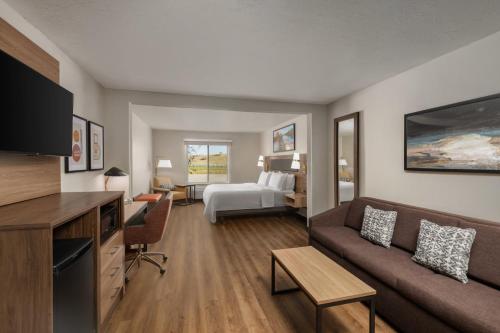 a living room with a couch and a bedroom at Garner Hotel Idaho Falls Southwest by IHG in Idaho Falls