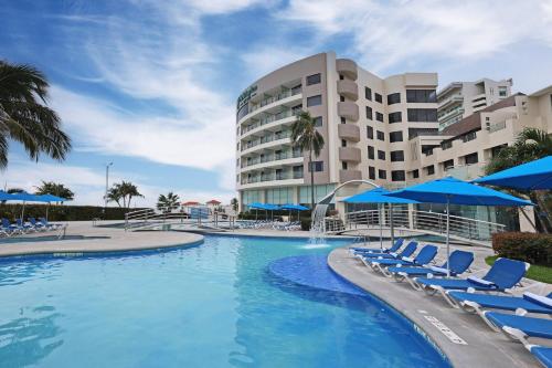 a swimming pool with chairs and a hotel at Holiday Inn Veracruz-Boca Del Rio by IHG in Veracruz