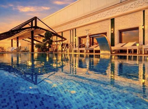 a swimming pool in front of a building at Prezident Palace Belgrade - Rooftop Pool & Spa Hotel in Belgrade