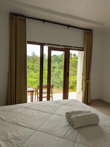 a bedroom with a bed and a large window at A'Resta Samasta Green Lodge in Praya