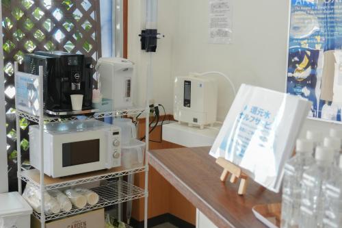 a kitchen with a microwave on a counter at 還元ホテル 名護東江 in Nago