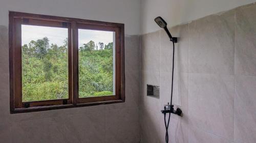 a shower in a bathroom with a window at A'Resta Samasta Green Lodge in Praya