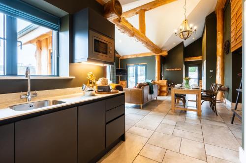 a kitchen with black cabinets and a living room at Bears Den in Ilkley