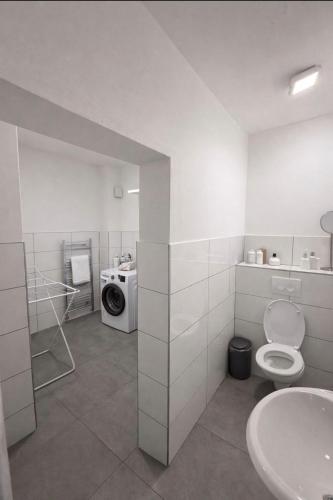 a bathroom with a toilet and a washing machine at Monteurzimmer Saarland in Merchweiler