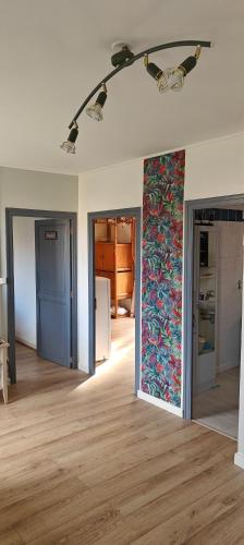 an empty room with a wall with a floral wallpaper at Passage des Jardins in Sorède