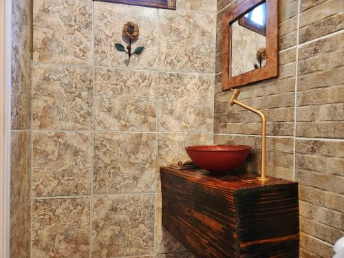 a bathroom with a bowl on top of a wooden cabinet at Suítes Aconchego - Pousada Rústica & Café da Manhã Especial in Lençóis