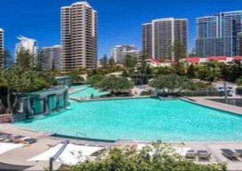 a large swimming pool in a city with tall buildings at Designer Rooms at Q1 resort - gclr in Gold Coast