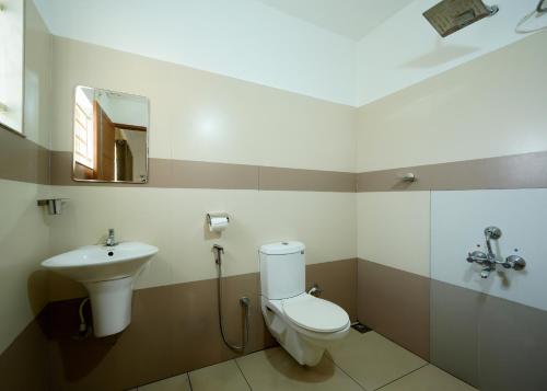 a bathroom with a toilet and a sink at BHRS Residency in Munnar