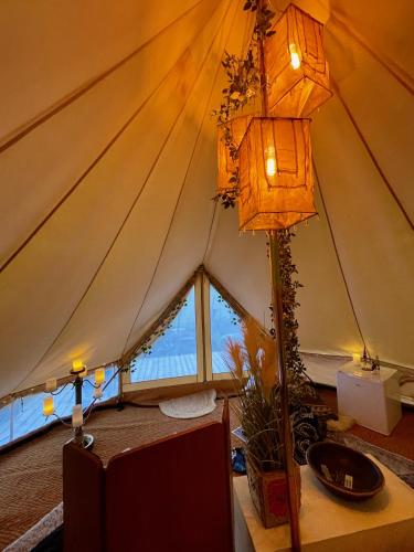 a room with a tent with a table and a lamp at Vista Vibes Glamping in Grillby