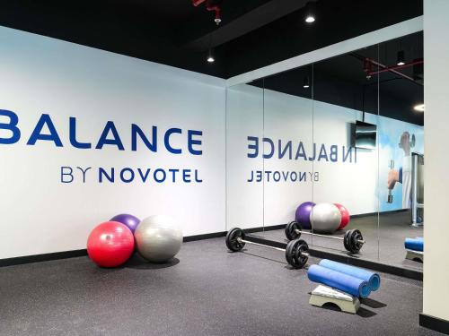 a gym with dumbbells and balls in front of a wall at Novotel Dubai World Trade Centre in Dubai