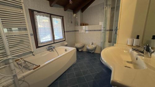 a bathroom with a tub and a sink and a toilet at Casa Zia Pia in Baveno