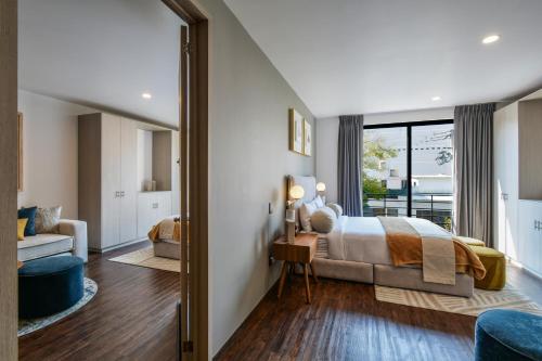 a bedroom with a bed and a living room at The Sterling Condesa in Mexico City