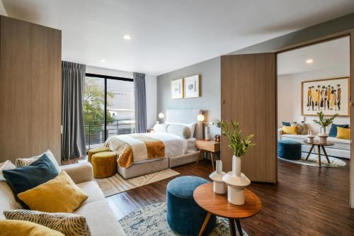 a bedroom with a bed and a living room at The Sterling Condesa in Mexico City